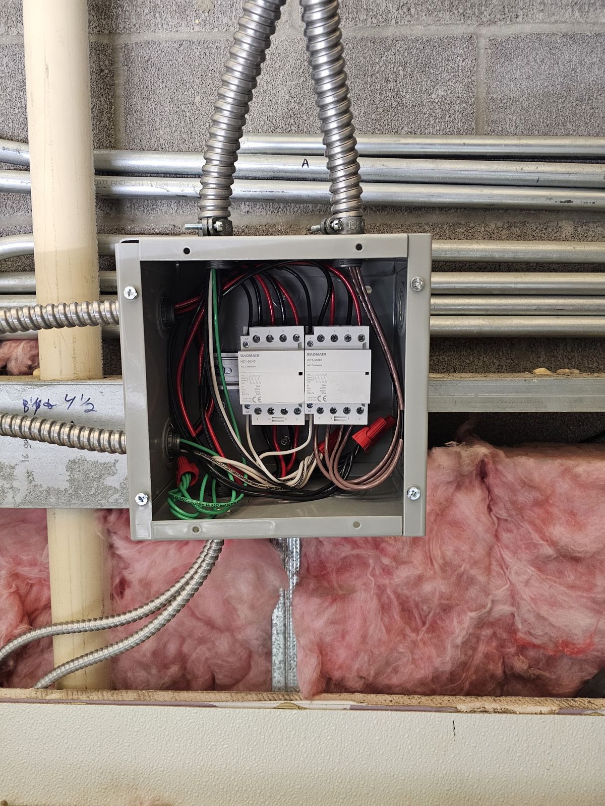 Control and surge suppression components wired inside an enclosure with conduit runs above
