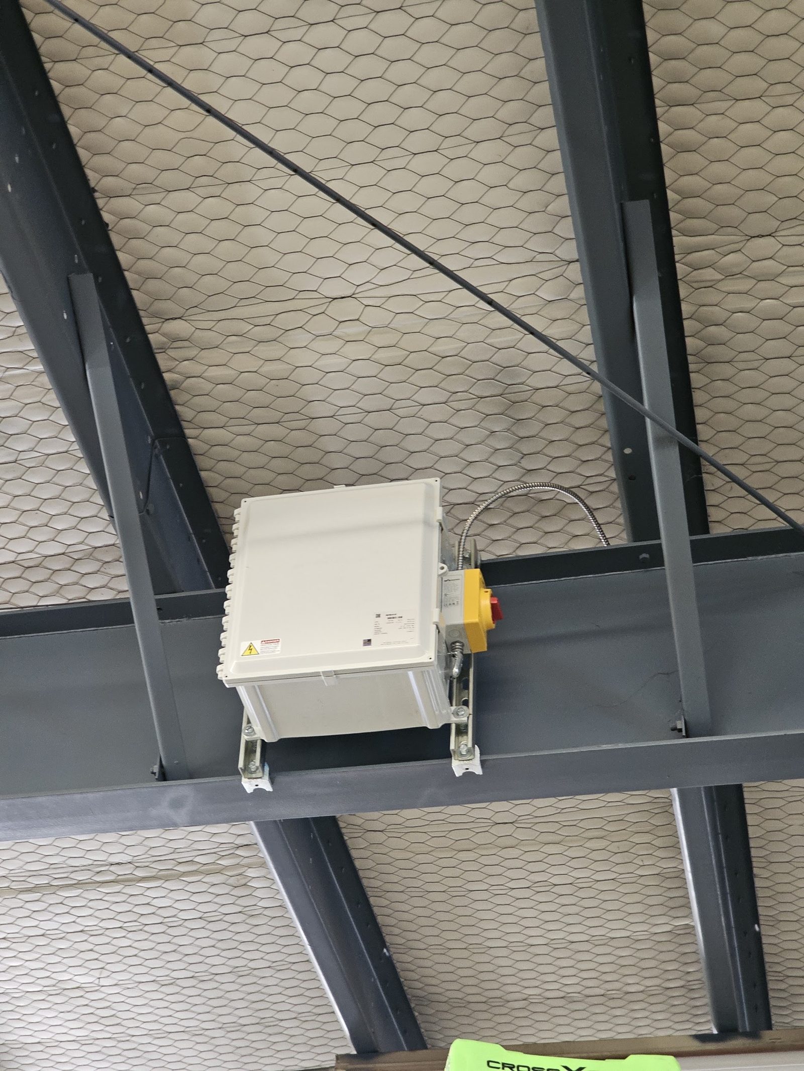 Equipment control enclosure mounted to overhead steel in a commercial building