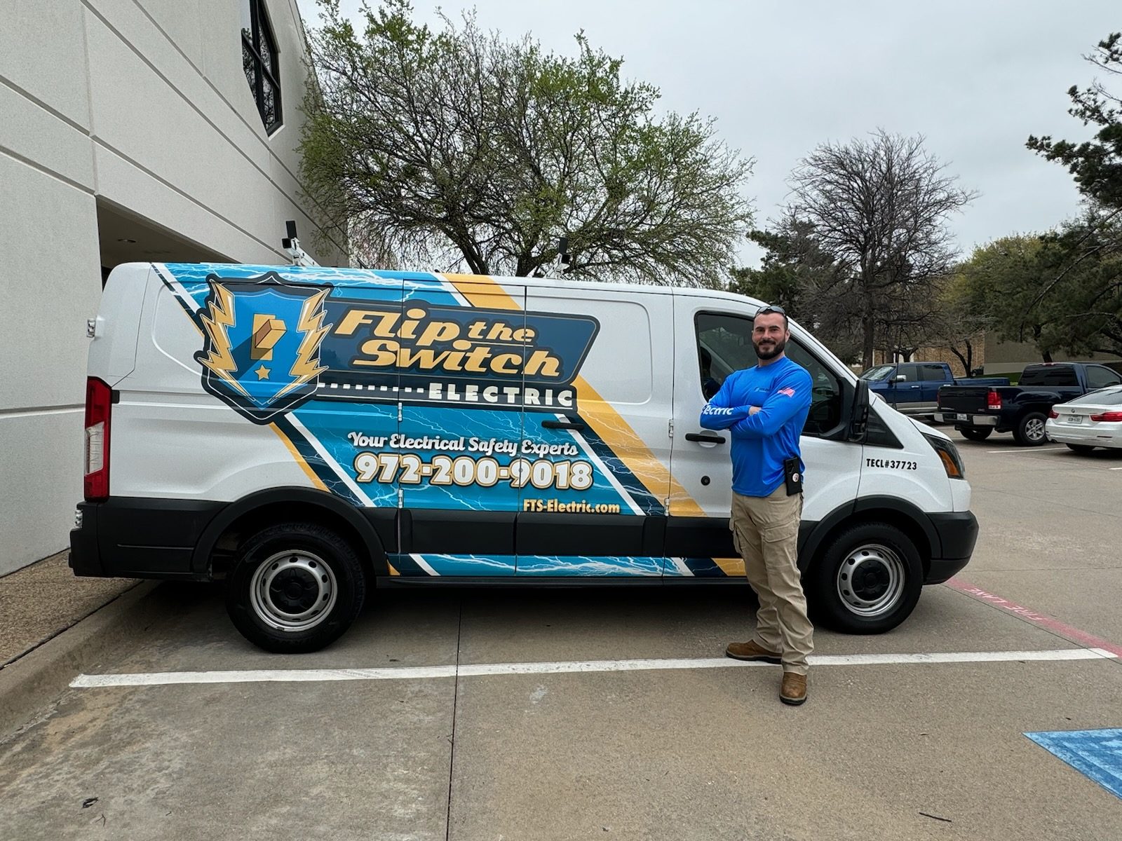 Flip the Switch Electric owner standing beside the company service van at a commercial property