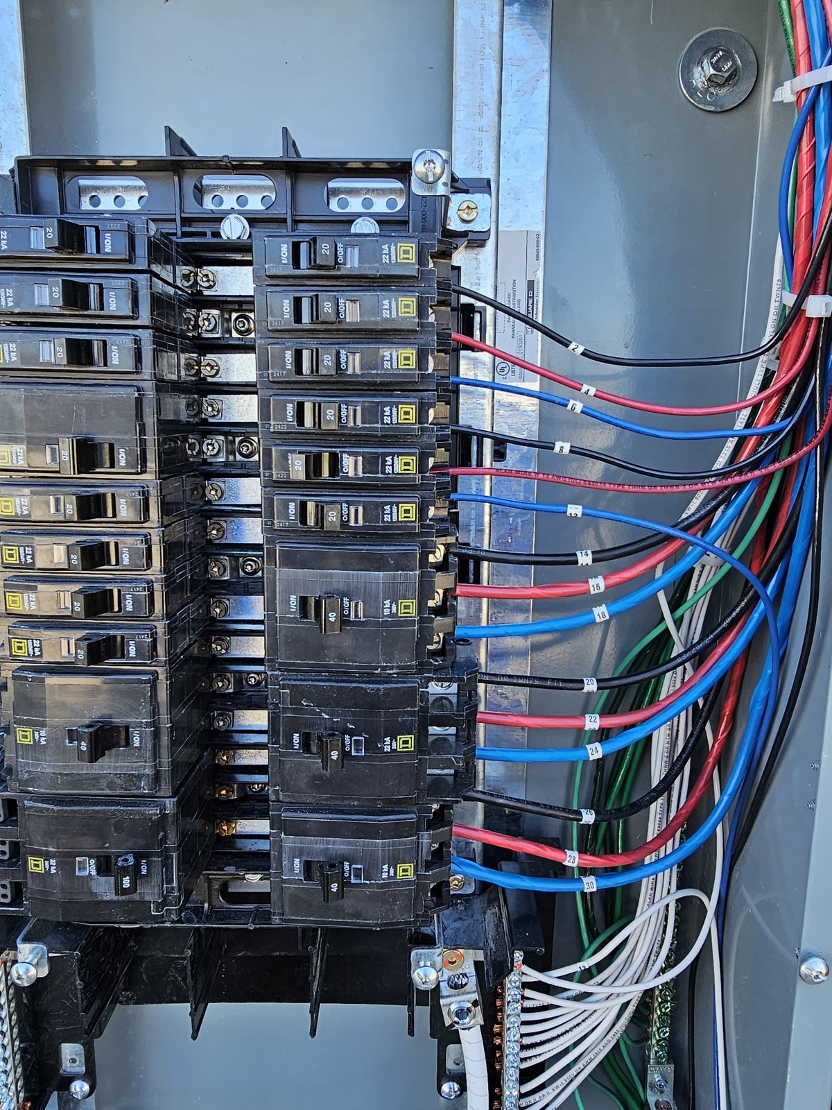 Interior of a commercial panel with neatly dressed branch circuit conductors and breakers