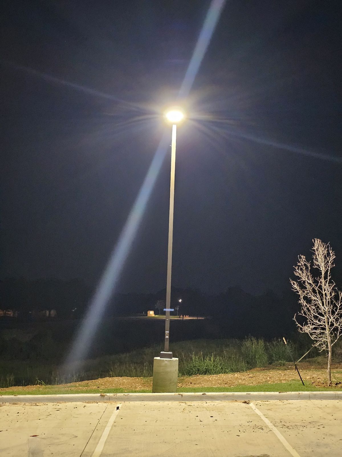 Parking lot light pole illuminated at night